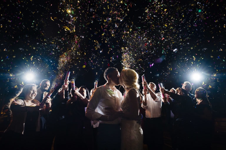 women kissing at wedding with confetti